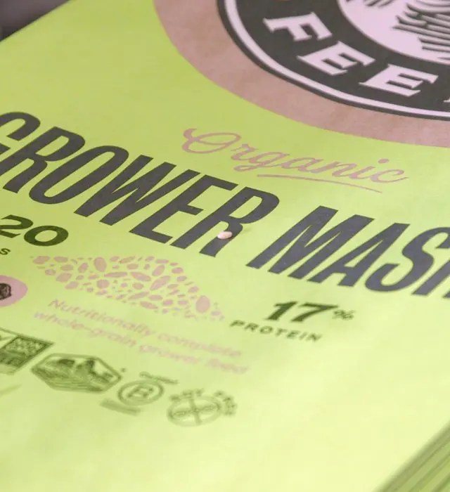 Close-up of an organic grower mash livestock feed bag, showing the product name, protein content and organic certification seals.