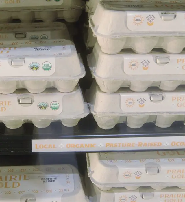Cartons of Prairie Gold organic eggs on a refrigerated shelf.