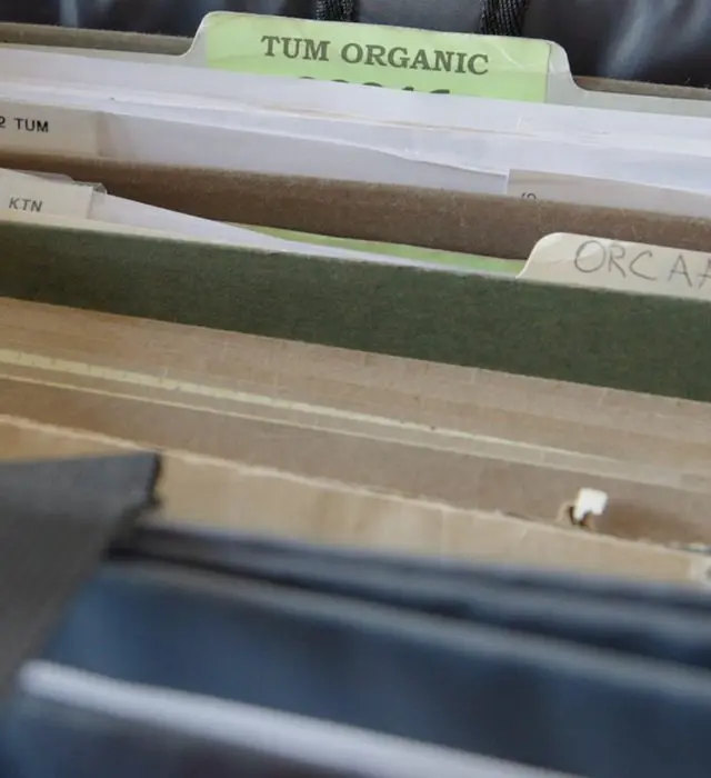 Organized organic inspection records in a filing bin.
